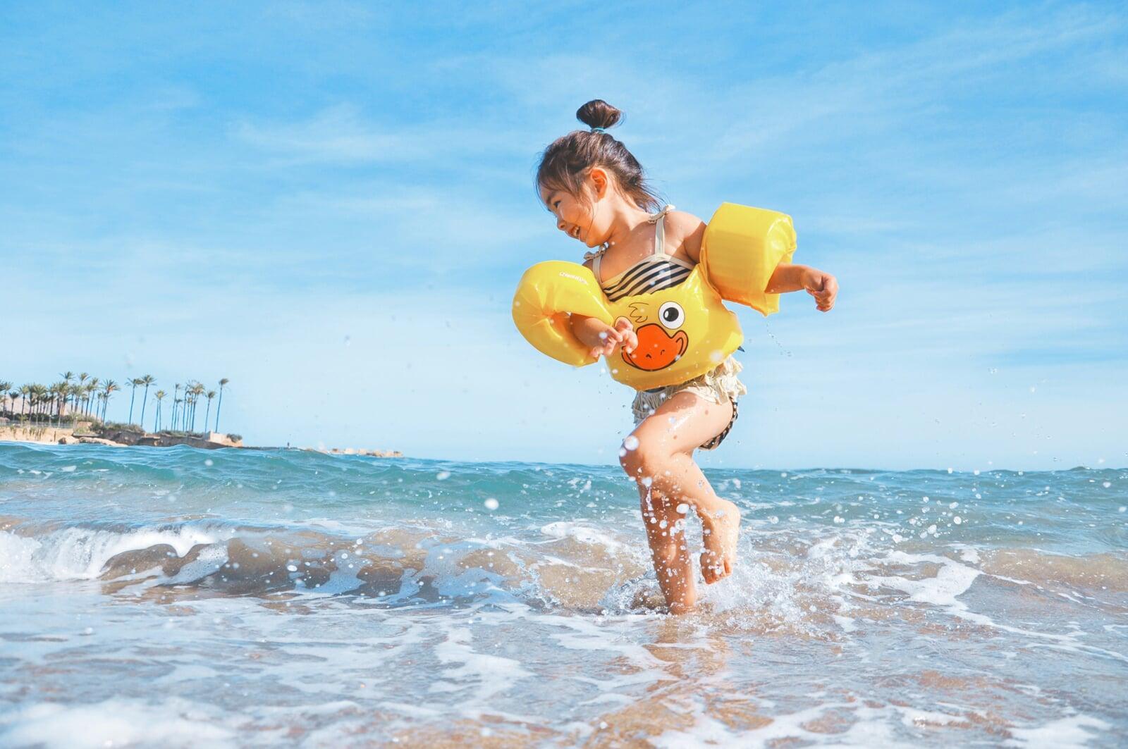 A child plays in the sea at a beach